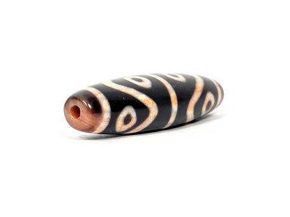 Angled end of antique Eight Eye Tiger Tooth Dzi — drill hole, tiger tooth and eye on body, taper visible