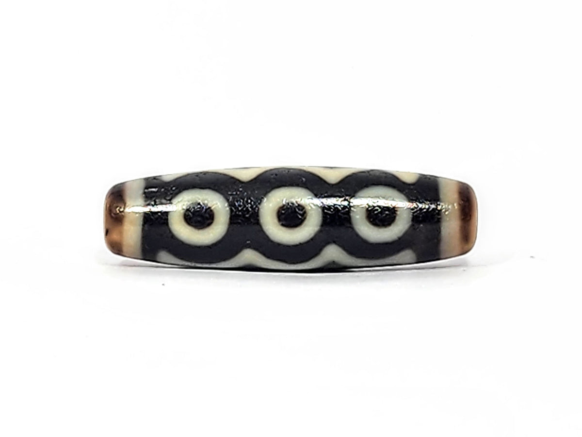 Face C of antique five eye dzi At-072625-5E, three cream eye rings linked by continuous arc on pitch-black agate, colonnade composition, 44.5mm, unretouched photography