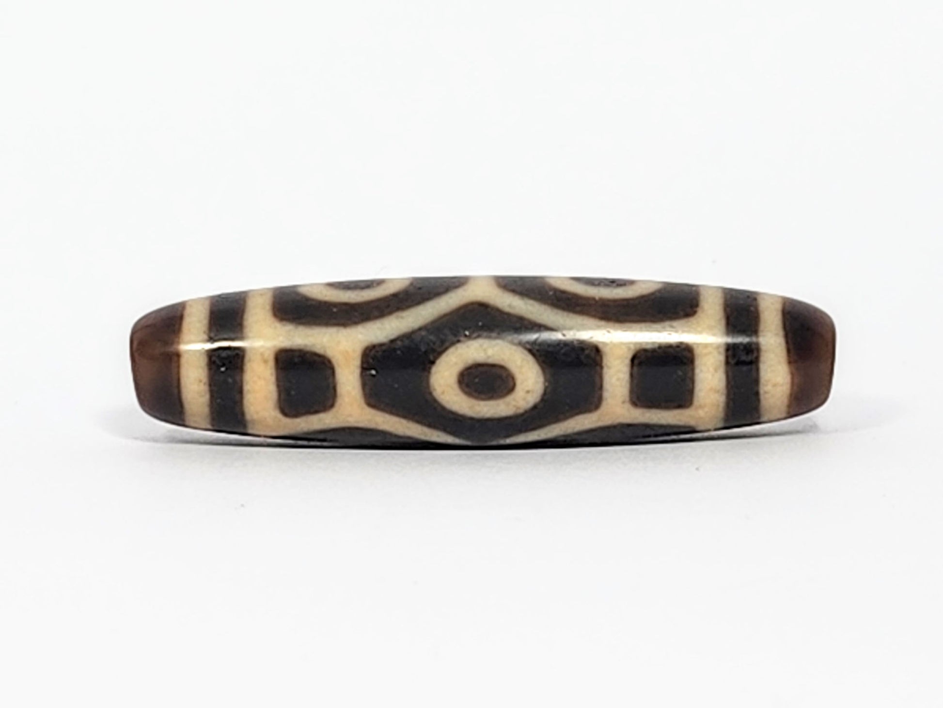 Antique Naga dzi bead face B showing architectural body scale with squared dark panels and central eye, At-050725-6EN3