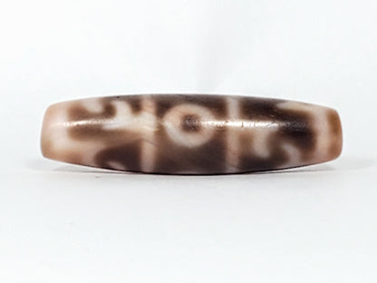 At-060326-GRRP, antique Guru Rinpoche paraphernalia dzi, 44.5×12mm, cream ground, chocolate-brown motif, unretouched