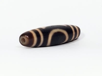 Angled end view of antique Heaven Earth dzi bead showing open oval U form and drill hole in dark agate cap, At-082324-HE3