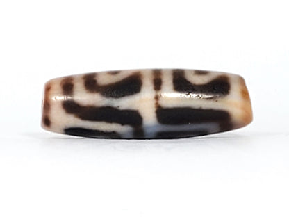 Second face of antique Four Leaf Bodhi dzi At-101624-FLB, rotational leaf-arch motif in cream, warm amber-brown agate ground, bloodspot inclusions, unretouched photography