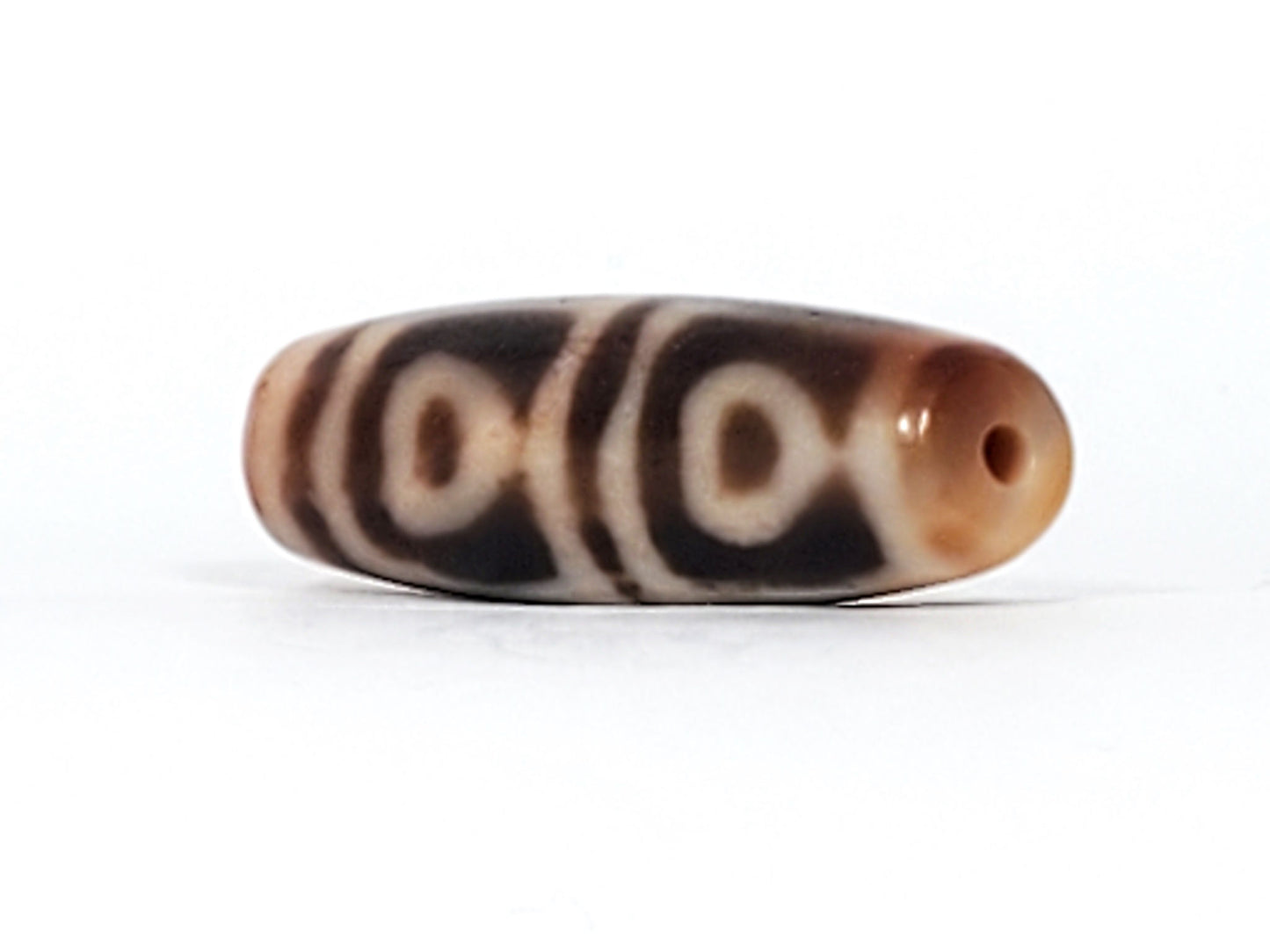 Another end cap of antique Four Leaf Bodhi dzi bead At-101624-FLB, warm brown agate tip, centred drill hole, compact barrel body, amber ground, unretouched photography
