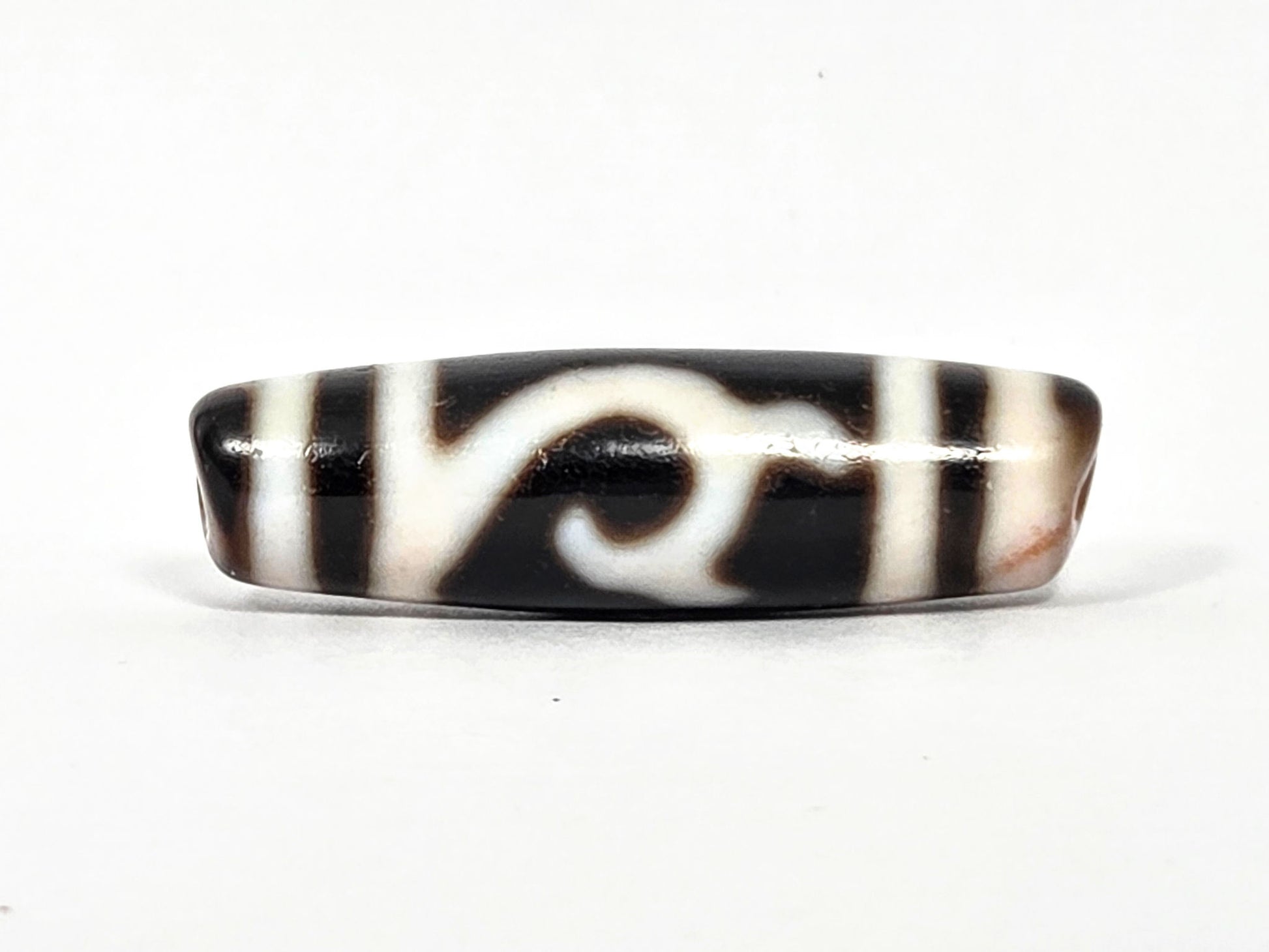 At-080426-GTBS antique Green Tara dzi bead 37.9×11.0mm, turn view showing scroll motif continuing around shoulder, cream-peach bloodspot zones, unretouched
