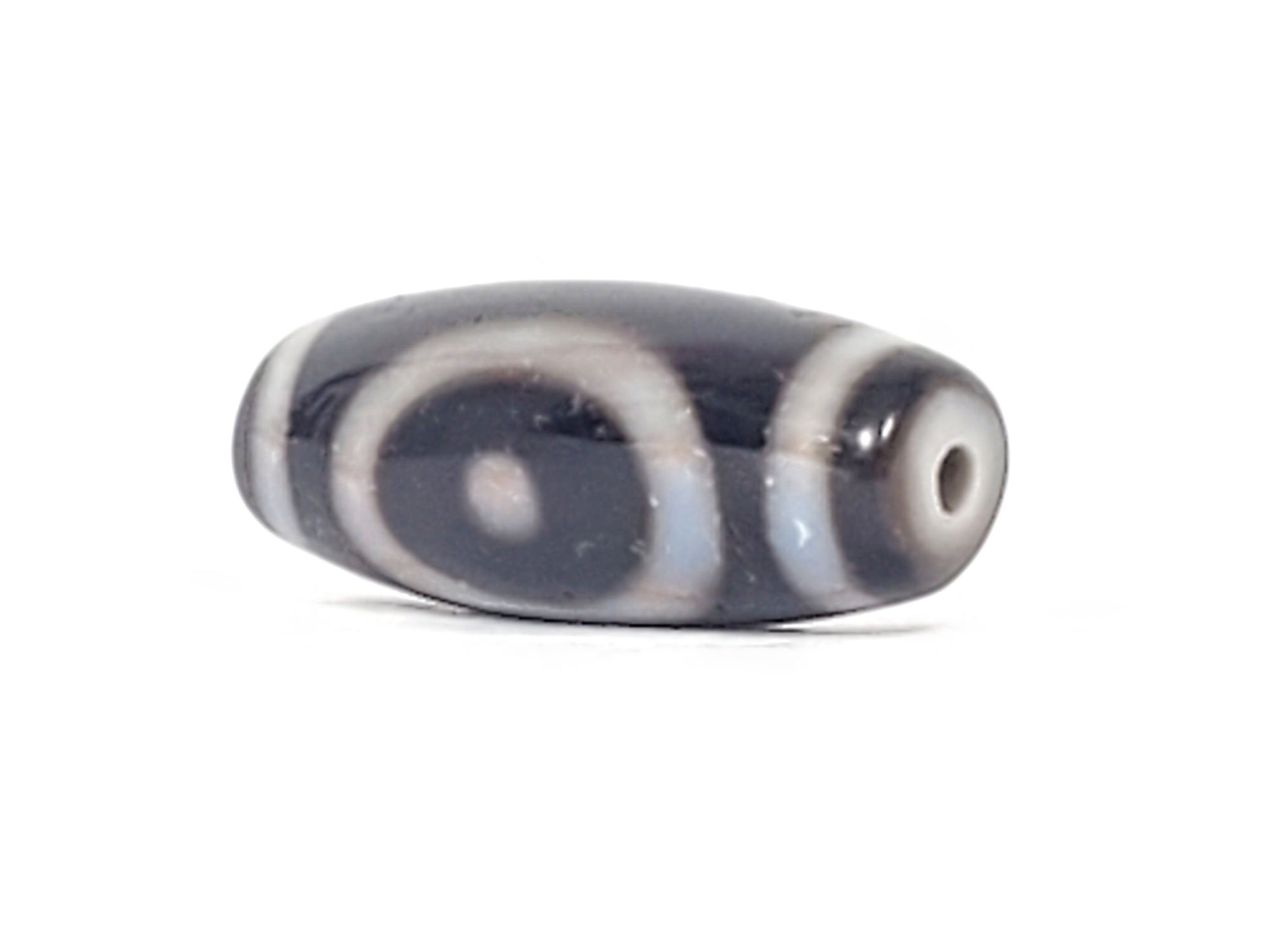 Antique heaven earth gate dzi — angled view, oval ring motif visible, drill hole at narrow right tip, At-0426-HGEG