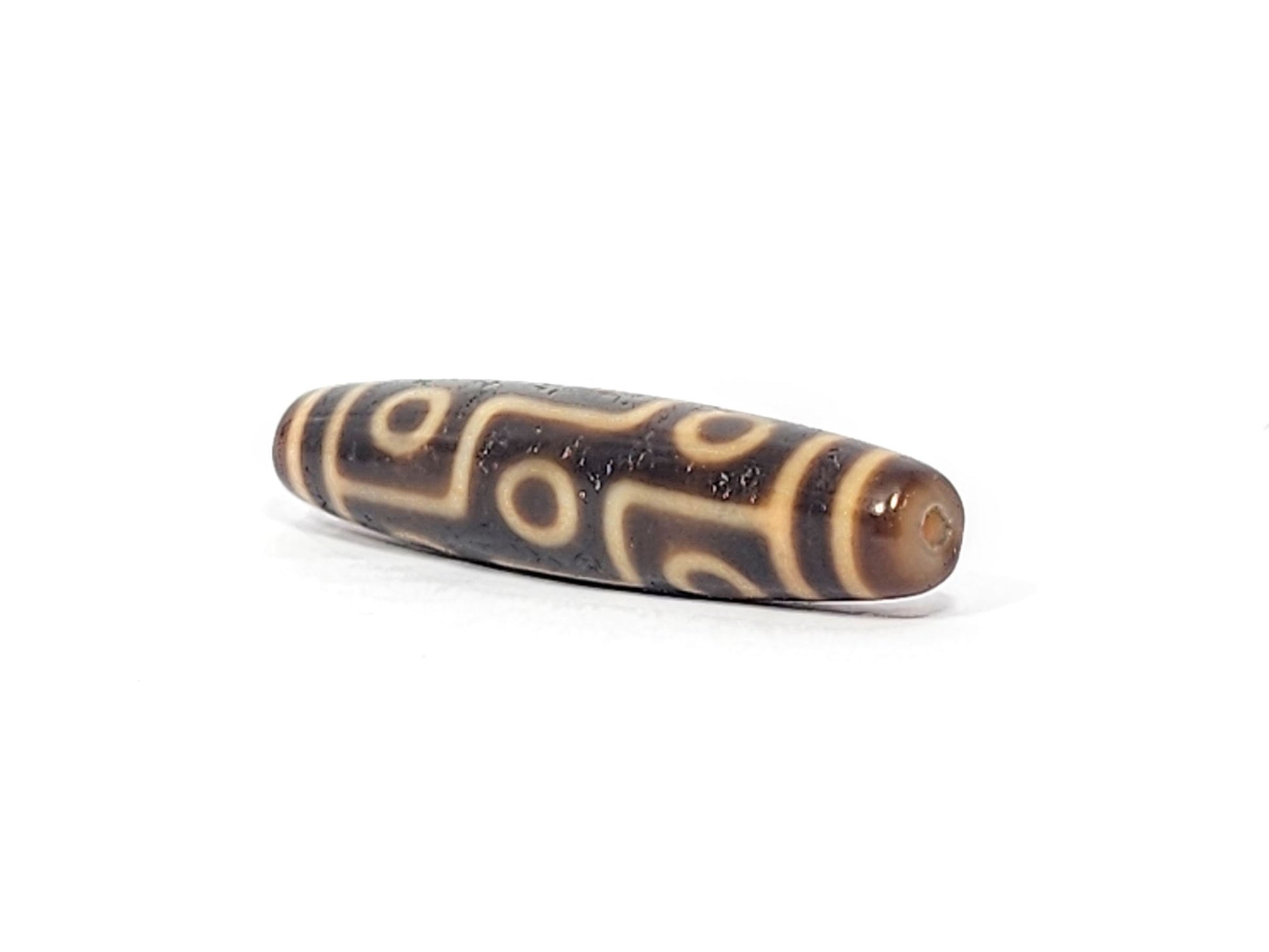 Opposite end of antique Tibetan Nine Eye dzi bead showing amber caramel dome end cap and eye network, At-051525-9E2