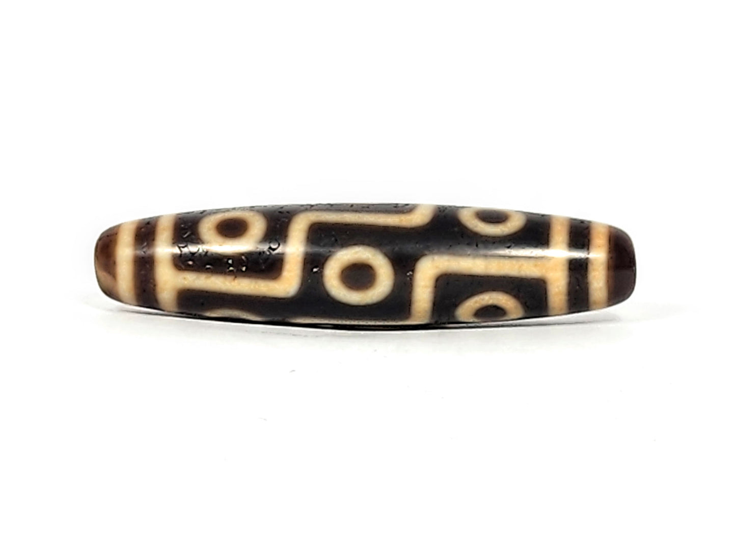 Antique Tibetan Nine Eye dzi bead face C showing staggered eye arrangement with L-shaped cream connectors, At-011625-9E