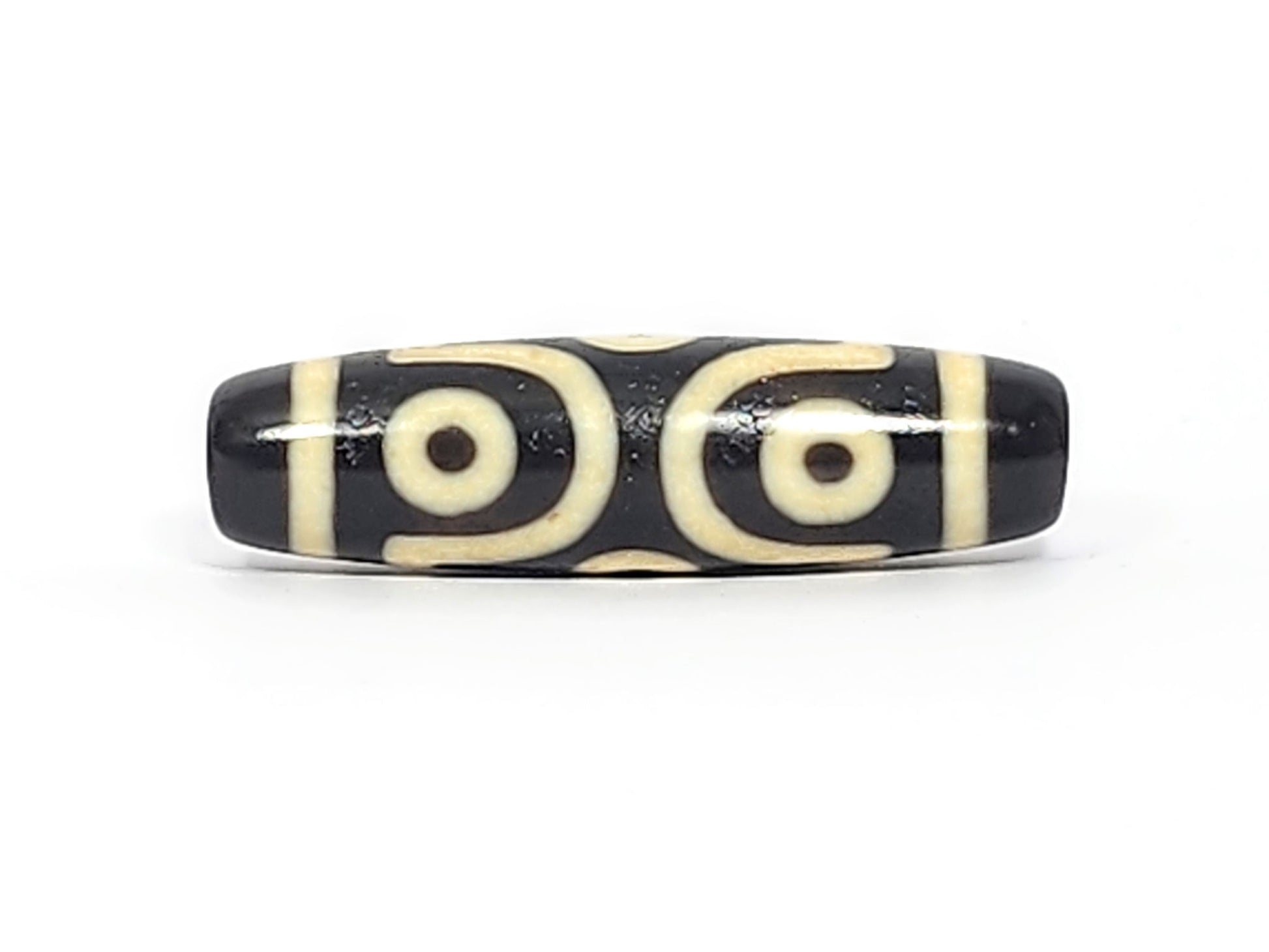 Antique six eye dzi At-042925-6E2, Face A, two open C-ring eyes with bold scroll connector on pitch-black agate, bright cream motif, 41.4mm × 11.4mm, unretouched