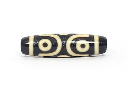 Antique six eye dzi At-042925-6E2, Face A, two open C-ring eyes with bold scroll connector on pitch-black agate, bright cream motif, 41.4mm × 11.4mm, unretouched