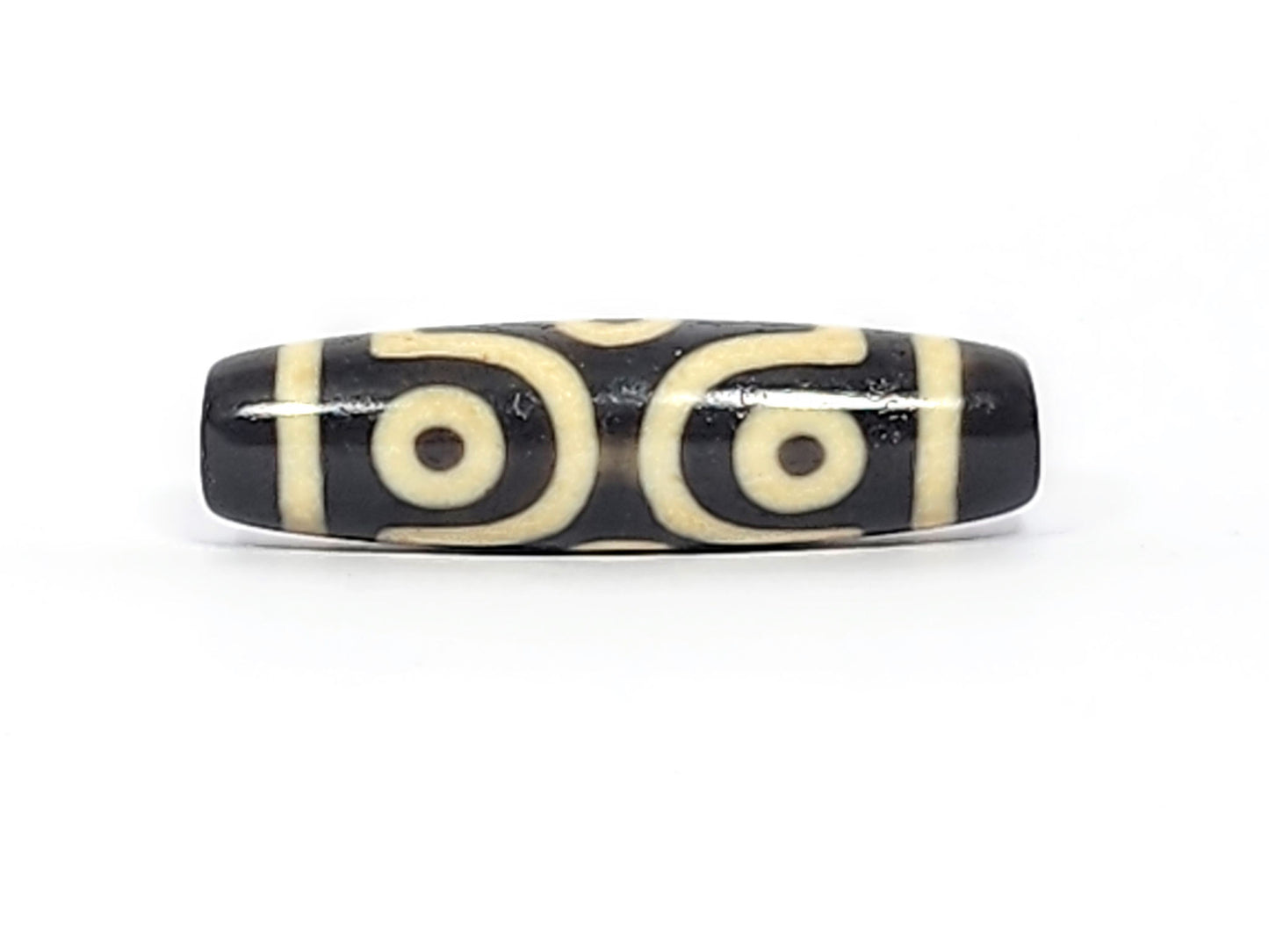 Face C of antique six eye dzi At-042925-6E2, two C-ring eyes with generous scroll arc on pitch-black agate, bold cream motif, paired-eye composition, unretouched