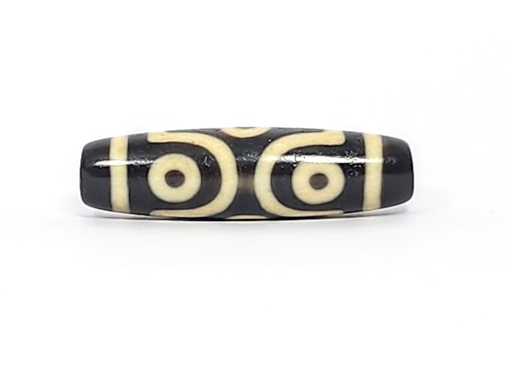 Face C of antique six eye dzi At-042925-6E2, two C-ring eyes with generous scroll arc on pitch-black agate, bold cream motif, paired-eye composition, unretouched