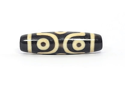 Face C of antique six eye dzi At-042925-6E2, two C-ring eyes with generous scroll arc on pitch-black agate, bold cream motif, paired-eye composition, unretouched