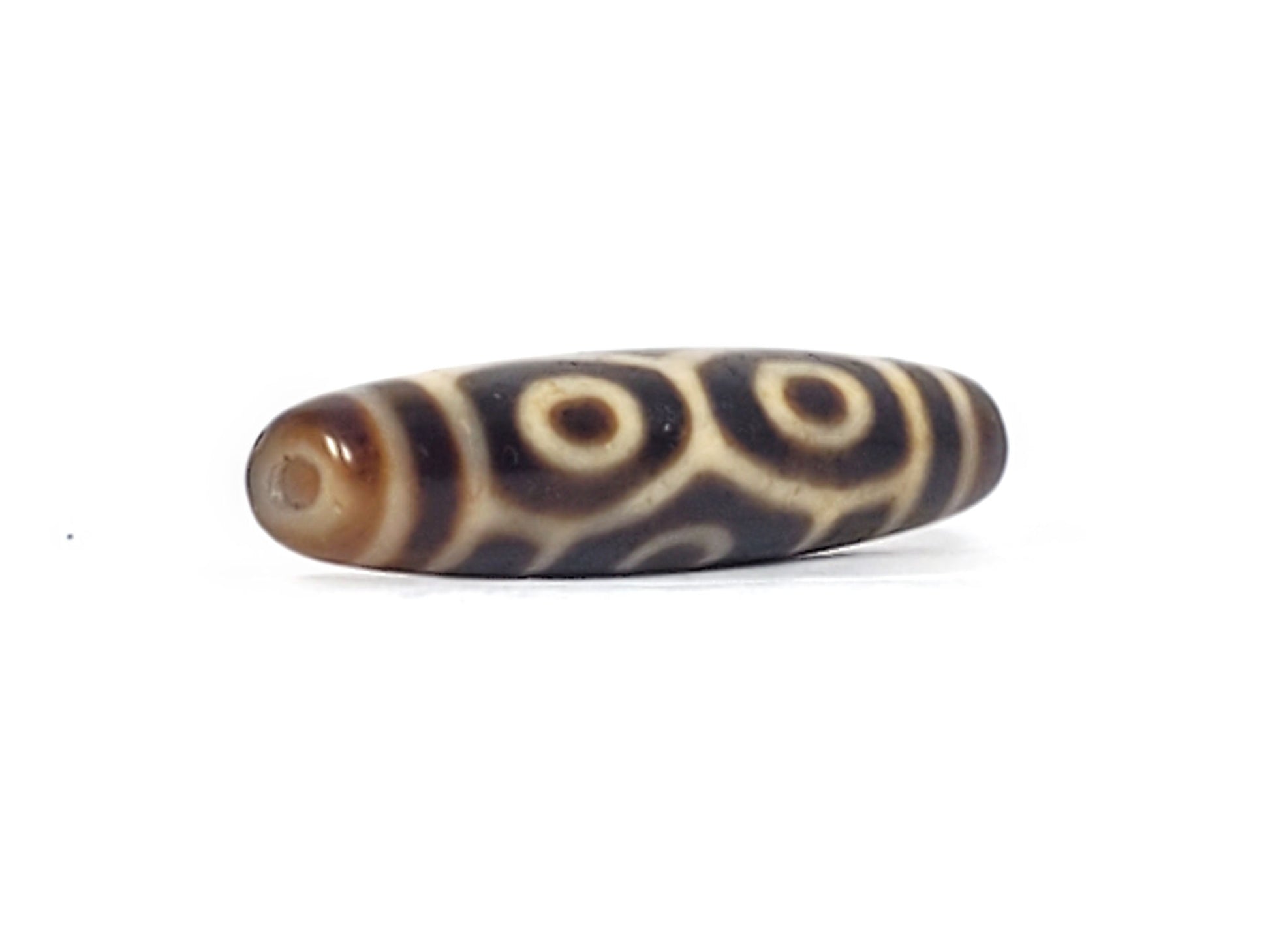 Opposite end of antique Tibetan Naga Dragon Eye dzi bead showing drill hole and paired eye motif, At-092524-6EN