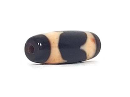 Three-quarter view of antique Tasso dzi At-092924-TaBS2, deep wine-brown end cap with drill hole, Tasso wave forms on pitch-black agate body, bloodspot in cream zone, unretouched