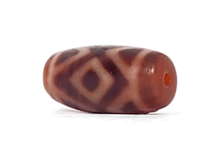 Three-quarter view of antique Three Diamond Eye Tiger Tooth dzi At-053126-3DETT, vivid terracotta-red end cap with orange drill hole, diamond motif on body, 27.5mm × 13.0mm, unretouched
