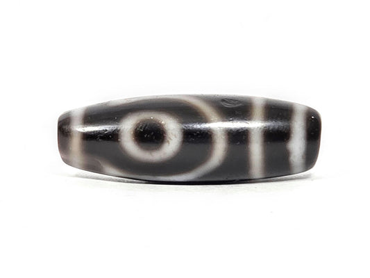Antique two eye dzi At-033126-2E4, Face A, fully closed concentric-ring eye on pitch-black agate, vertical cream stripes right, 37.3mm × 12.8mm, unretouched photography