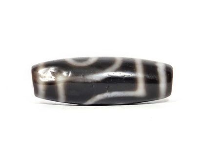 Medicine dig face of antique two eye dzi At-033126-2E4, two excavation marks visible on cream scroll motif, pitch-black agate, authentic age marker, unretouched