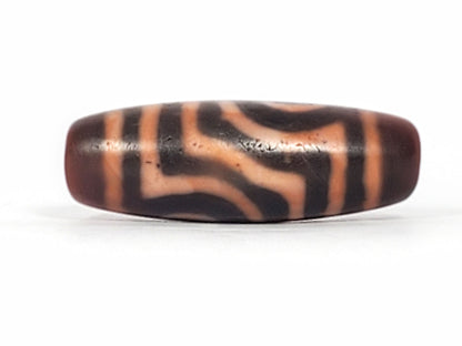 At-053126-2E6, scroll connector face, flowing terracotta-orange lines on mahogany-brown, aged surface, unretouched