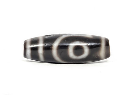 Face B of antique two eye dzi At-033126-2E4, open C-ring eye on pitch-black agate, incomplete outer arc, vertical cream stripes, 37.3mm × 12.8mm, unretouched photography