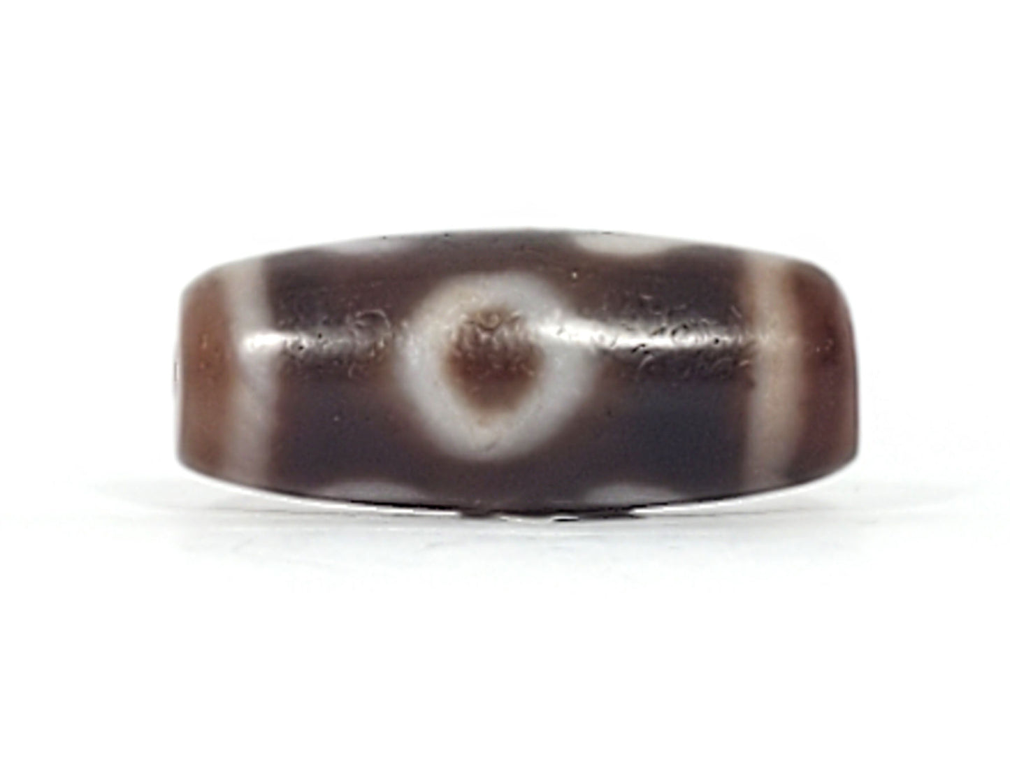 Second face of antique Double Bat Two Eye dzi At-053026-DB2E, bat and eye motif composition on dark brown agate, cream patterning, bloodspot inclusions visible, unretouched