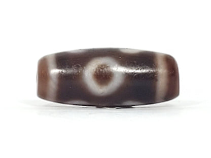 Second face of antique Double Bat Two Eye dzi At-053026-DB2E, bat and eye motif composition on dark brown agate, cream patterning, bloodspot inclusions visible, unretouched
