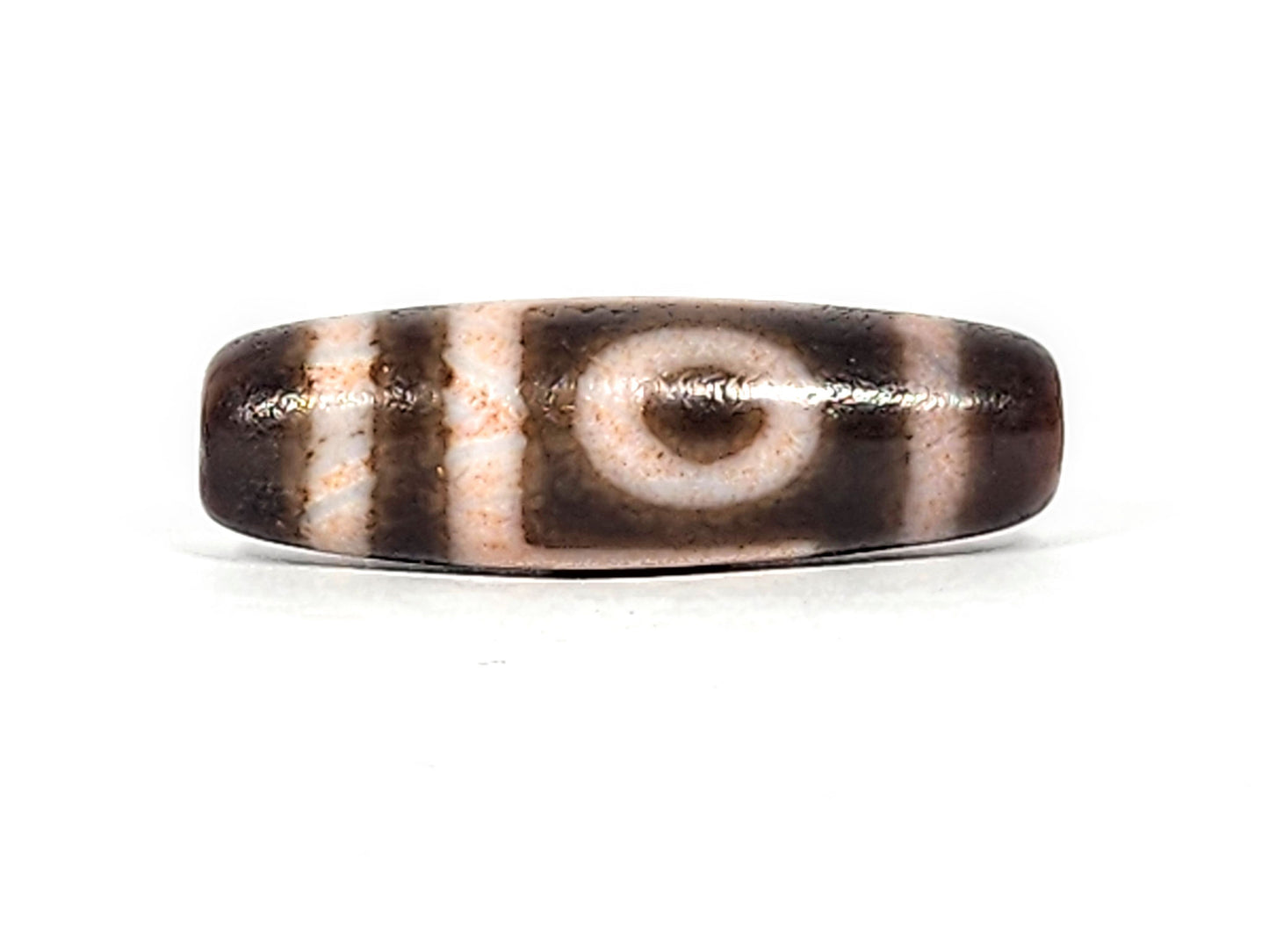 Antique two eye dzi bead At-092724-2EBS, Face A, full profile showing one closed concentric-ring eye, rose-peach cream stripes on dark brown agate, 41.0mm × 13.0mm, unretouched