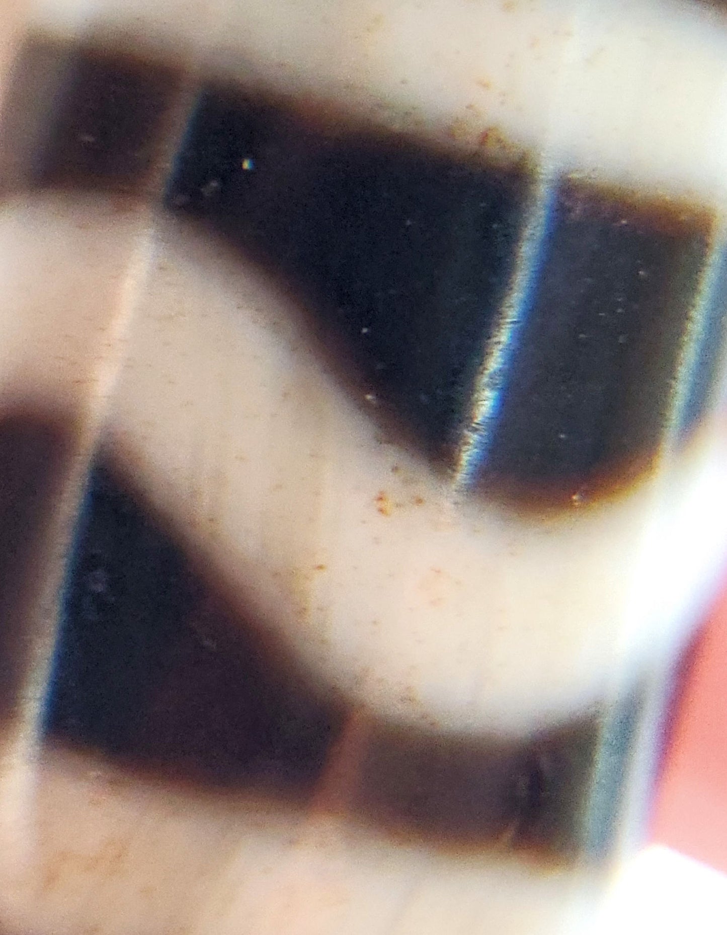 Macro lens view of antique Wave Stripe dzi showing wave-stripe boundary and orange-red bloodspot inclusions, At-052526-WS