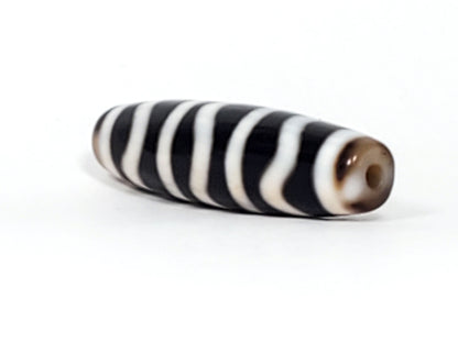 End view of antique Wave Stripe dzi bead showing drill hole with brown agate bloodspot surround, At-052526-WS