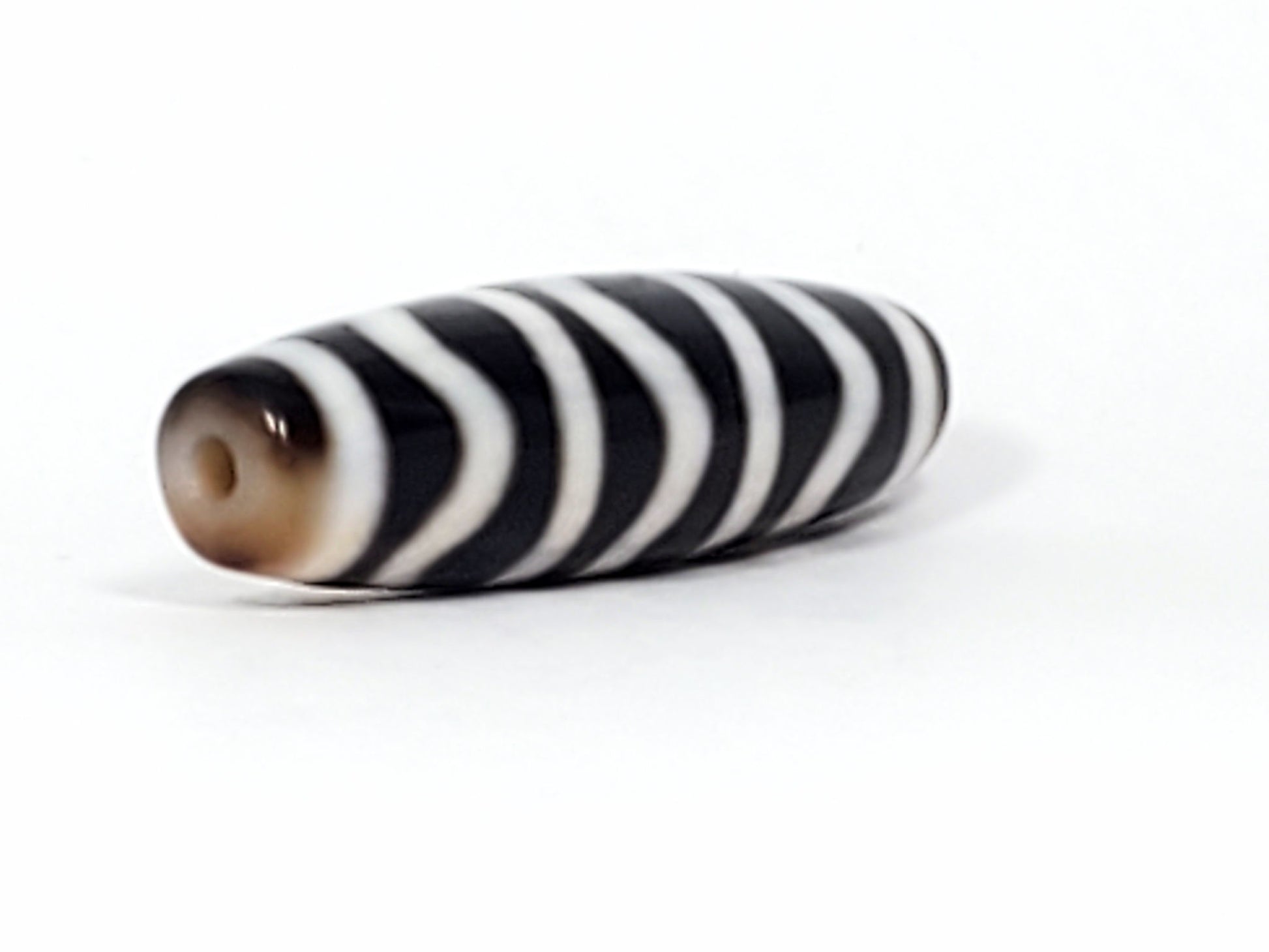 Opposite end view of antique Wave Stripe dzi bead showing drill hole and warm brown agate cap, At-052526-WS