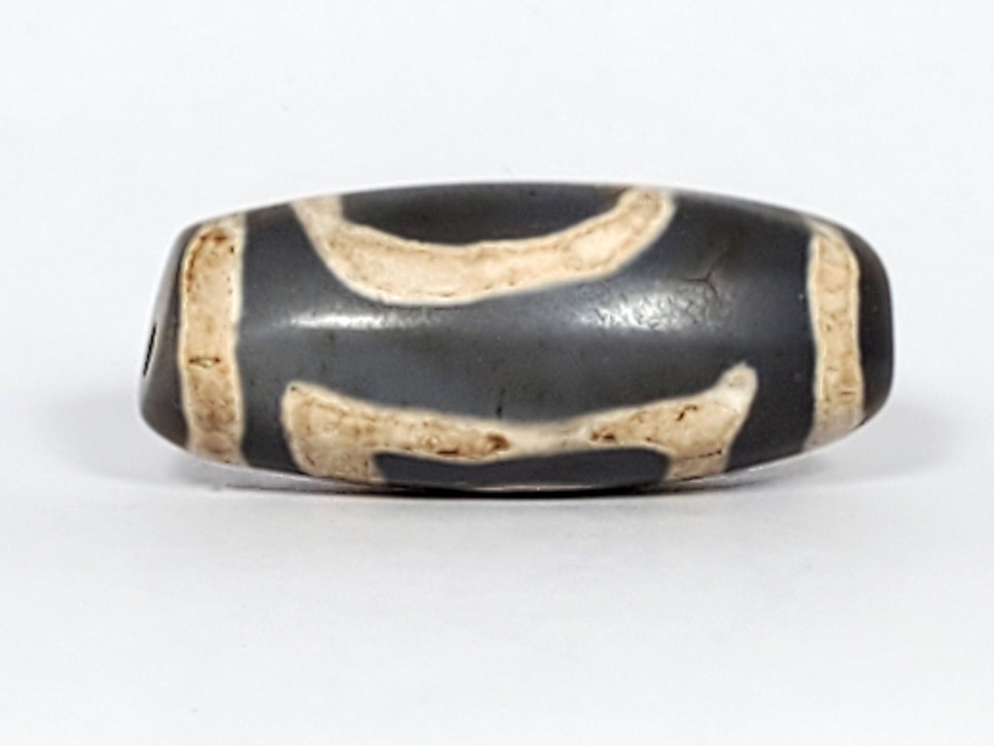 At-022624-HEG, Face B showing paired wave-arc connector forms, warm cream on deep charcoal-grey agate, unretouched