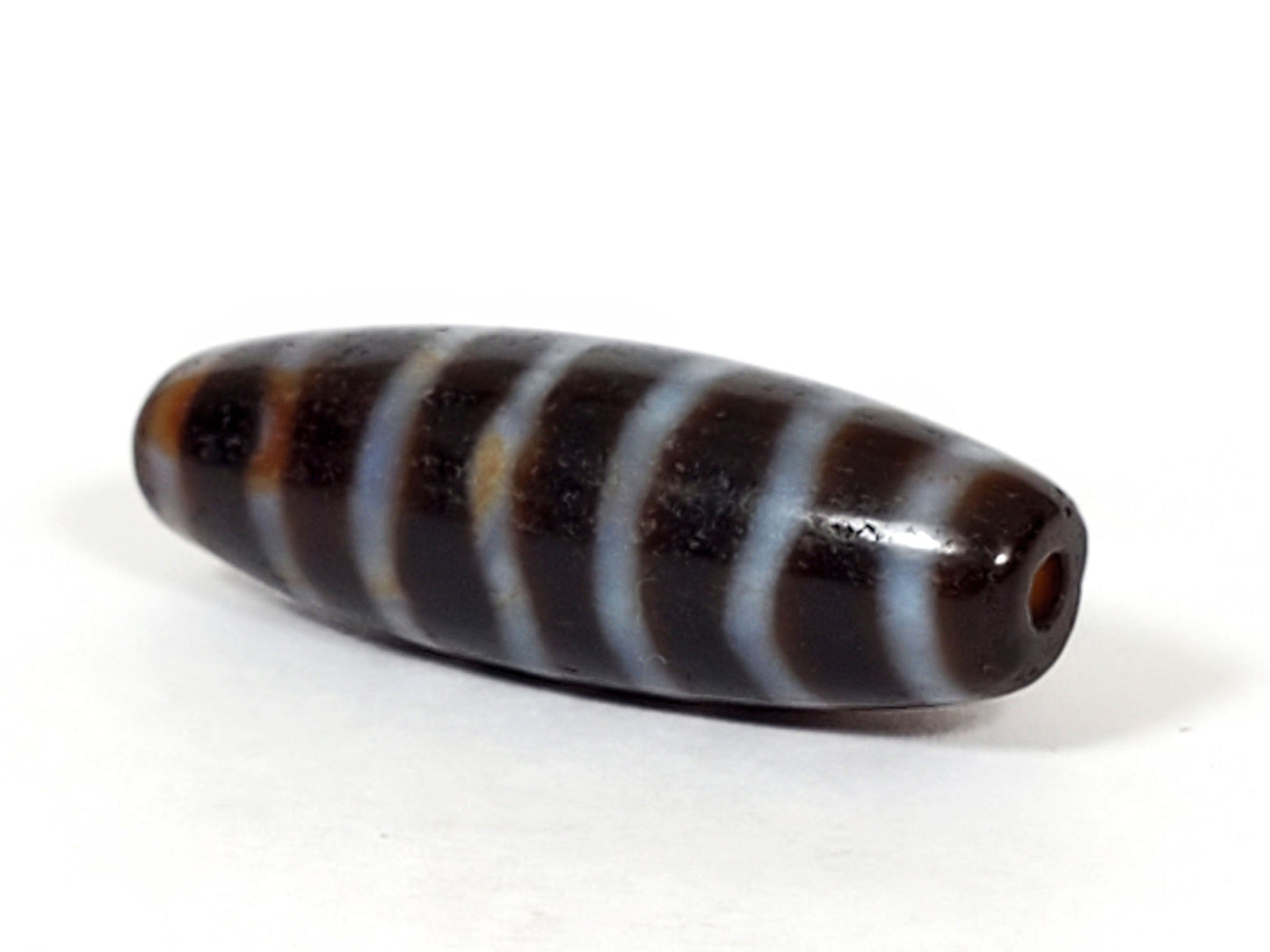 At-053126-WS2, second end-cap angled view, wave-stripe wrapping full body, elongated spindle form, unretouched