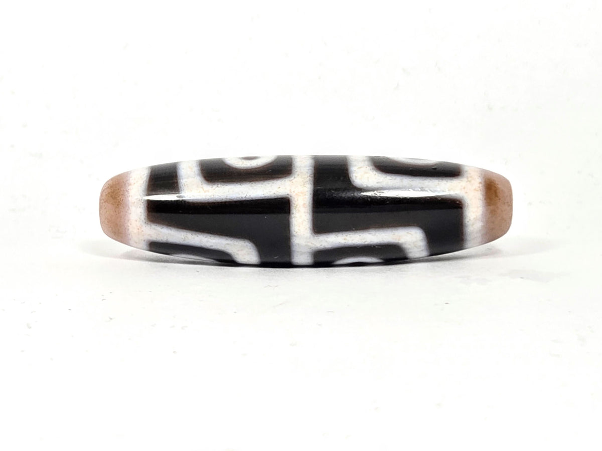 At-042626-4E3 connector face, bold white labyrinthine step lines on pitch-black agate, unretouched