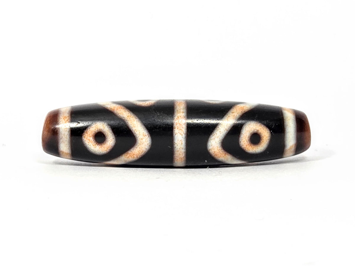 Second end of antique Eight Eye Tiger Tooth Dzi — drill hole, warm amber agate, eye circles wrapping end
