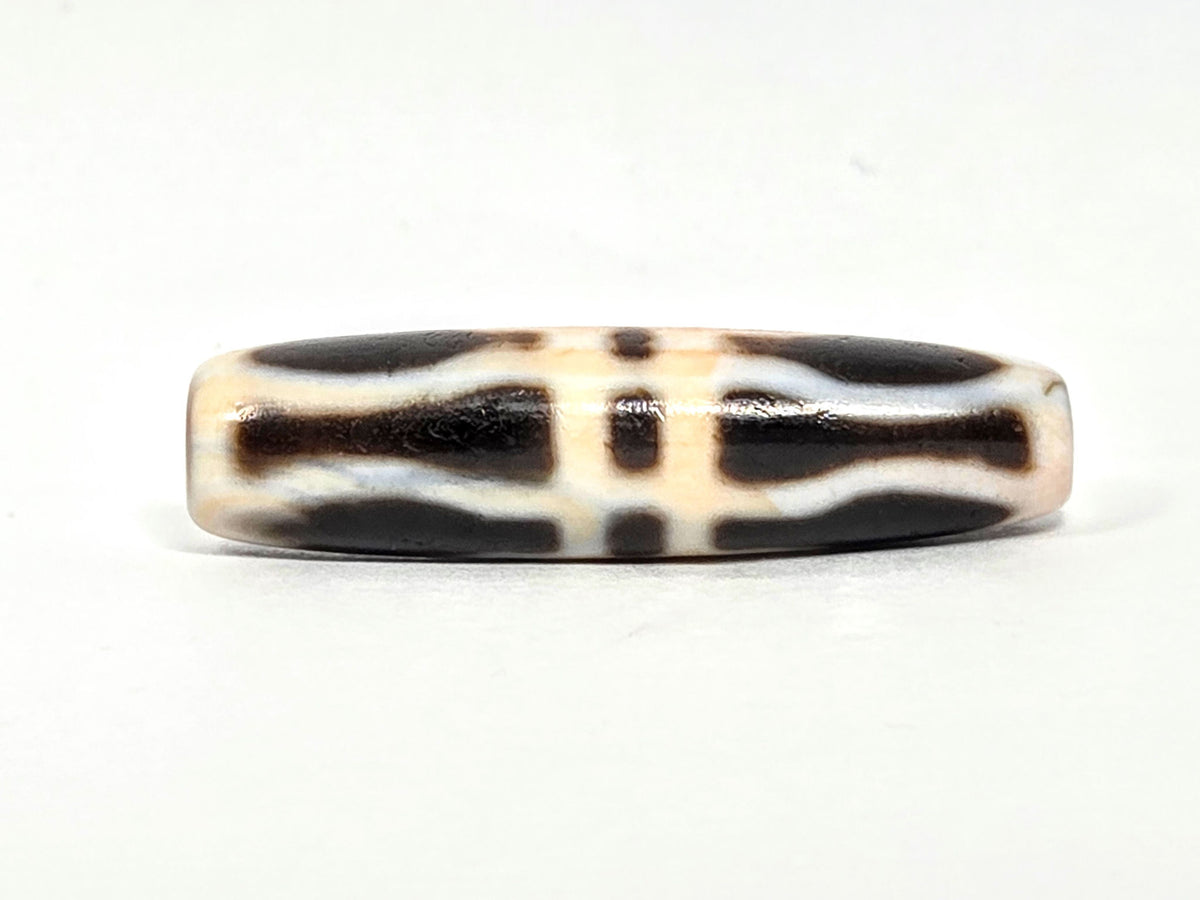 At-070626-3VjBS rotated face 5, triple vajra dzi, cream-dominant, warm terracotta cinnabar cast, unretouched