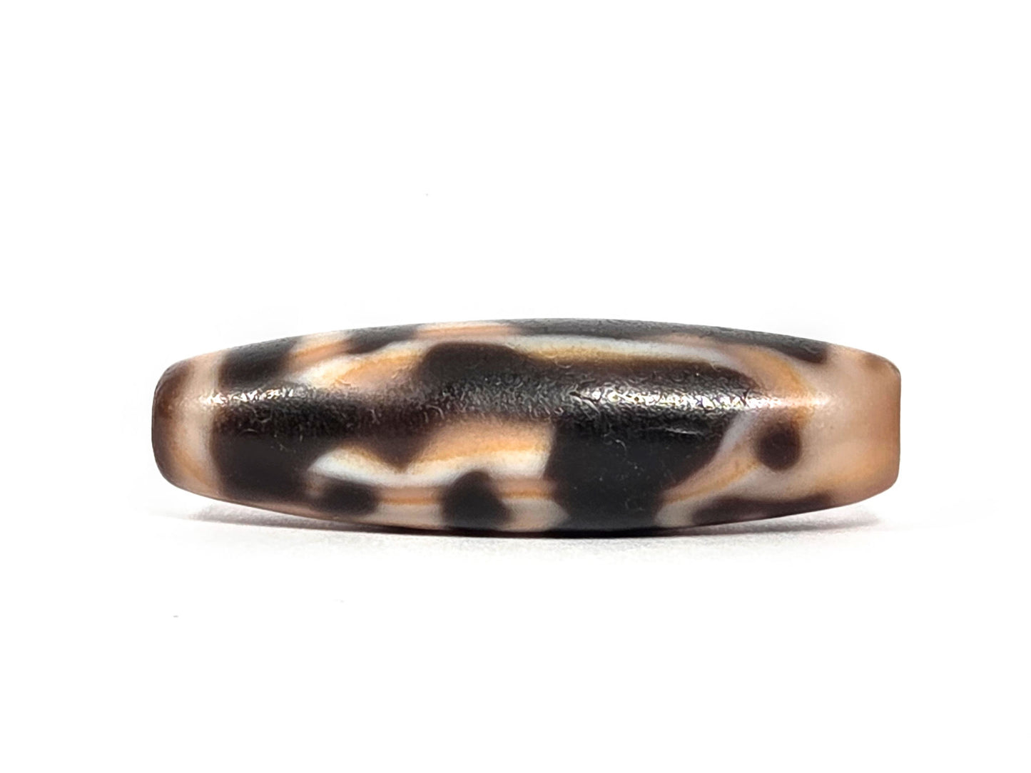 At-072226-LBBS Lotus Bud bloodspot face B — scattered dark patches, cream zones, warm dark brown ground, unretouched.