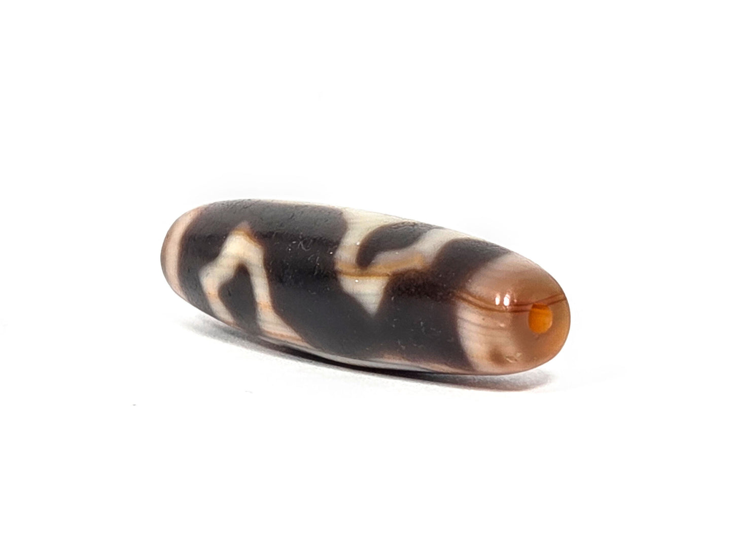 At-072226-LBBS end angle A — warm orange-brown end cap, vivid orange drill opening, motif wrap visible, unretouched. 