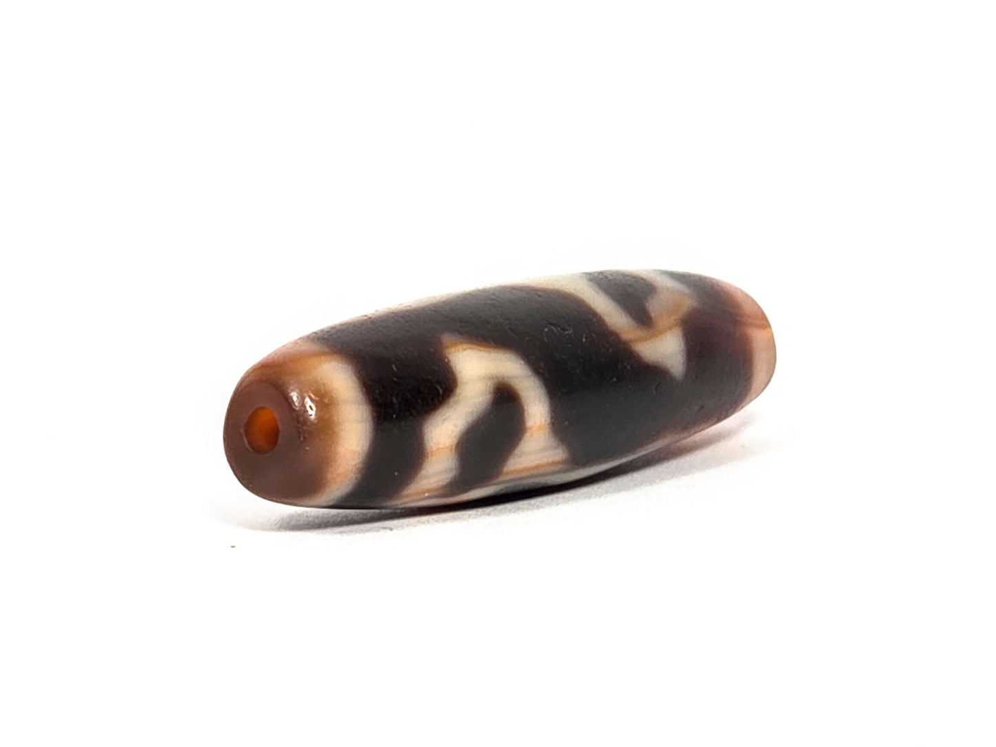 At-072226-LBBS end angle B — opposite warm orange-brown end cap, dark body, cream motif elements, unretouched.