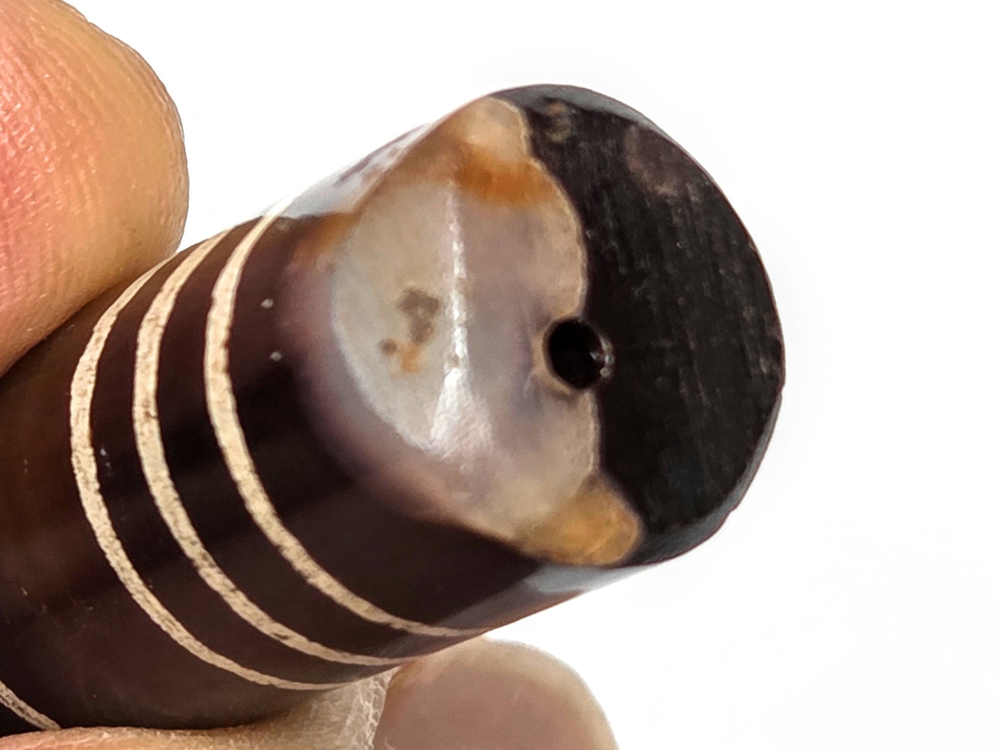 Ac-062226-6Str, macro chipped end, milky-white and orange-brown agate banding exposed, drill hole centred, unretouched