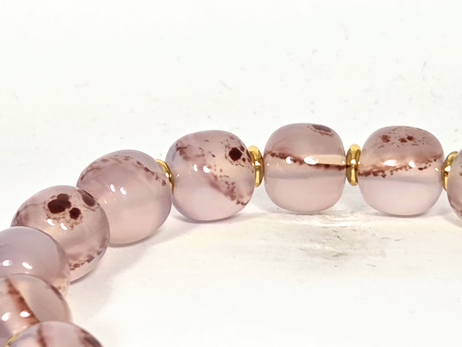 N-030526-CB2 bead detail, dusty mauve-rose chalcedony, cinnabar dot clusters, gold spacers between beads, unretouched