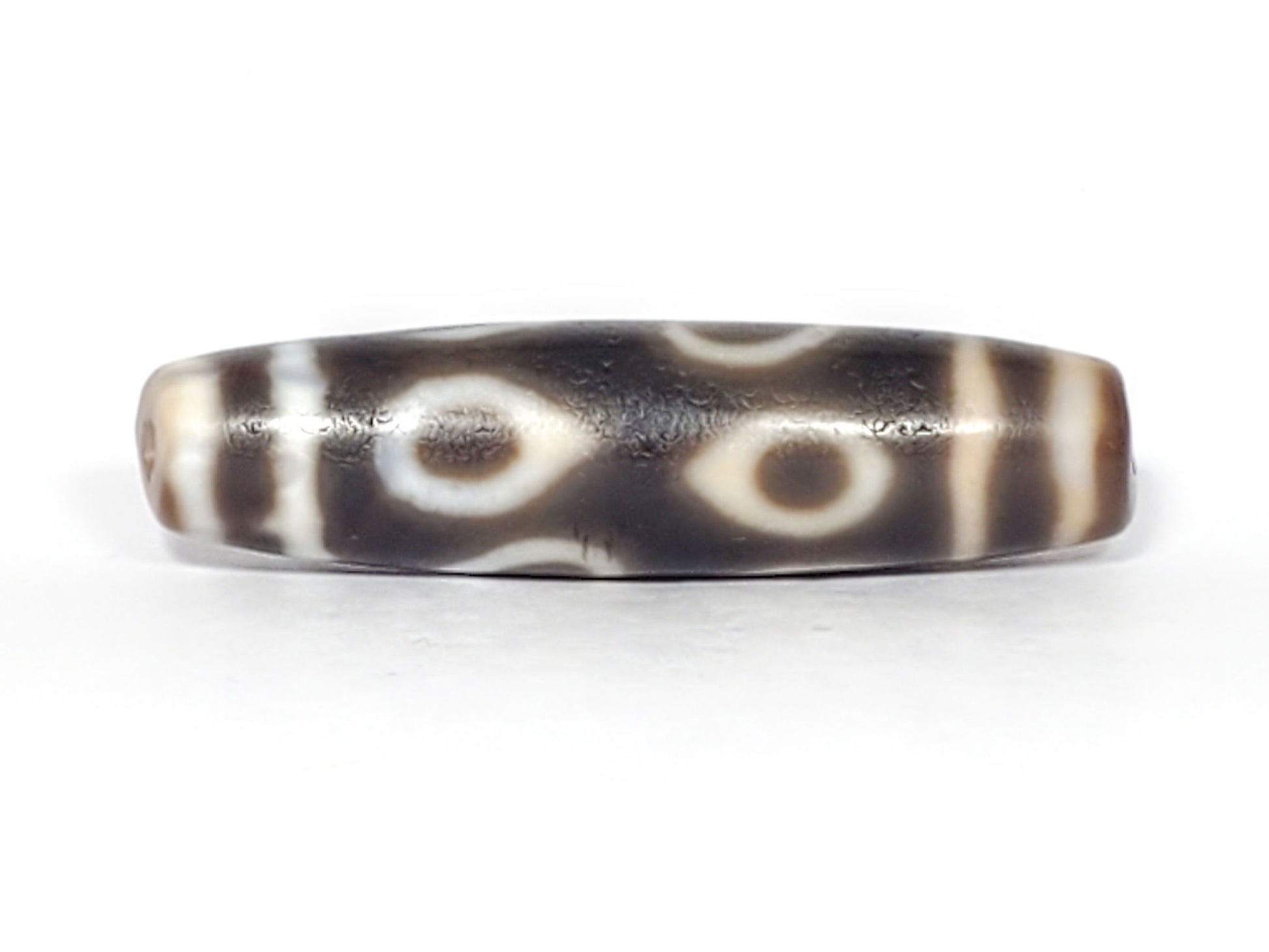 Ac-061926-DC4E eye face A, two closed ring eyes, warm honey-brown interiors, dark grey-brown ground, unretouched