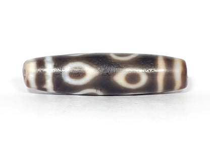 Ac-061926-DC4E eye face A, two closed ring eyes, warm honey-brown interiors, dark grey-brown ground, unretouched