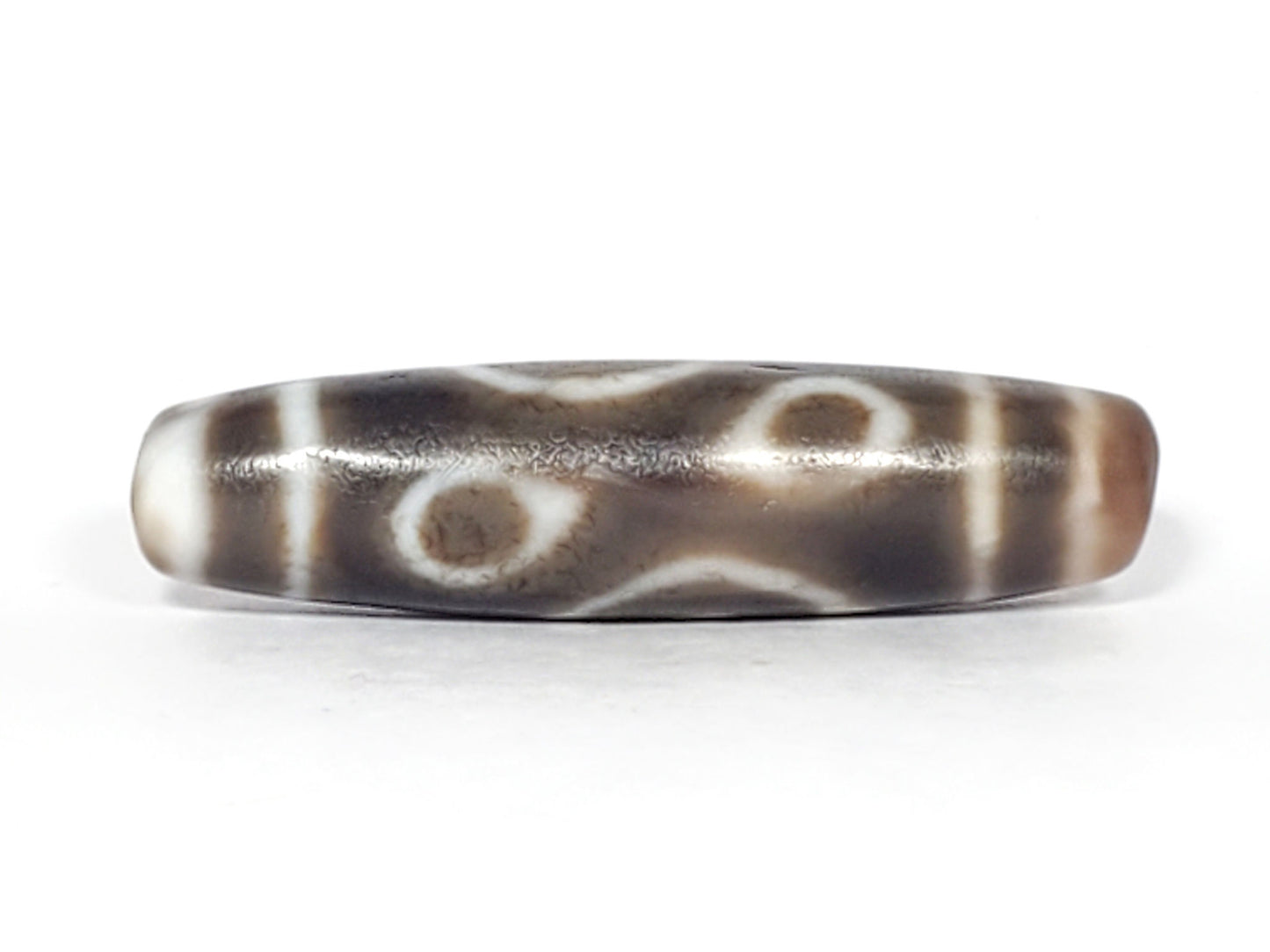 Ac-061926-DC4E eye face B, two closed ring eyes, diffuse cream-white rings, warm agate interiors, unretouched