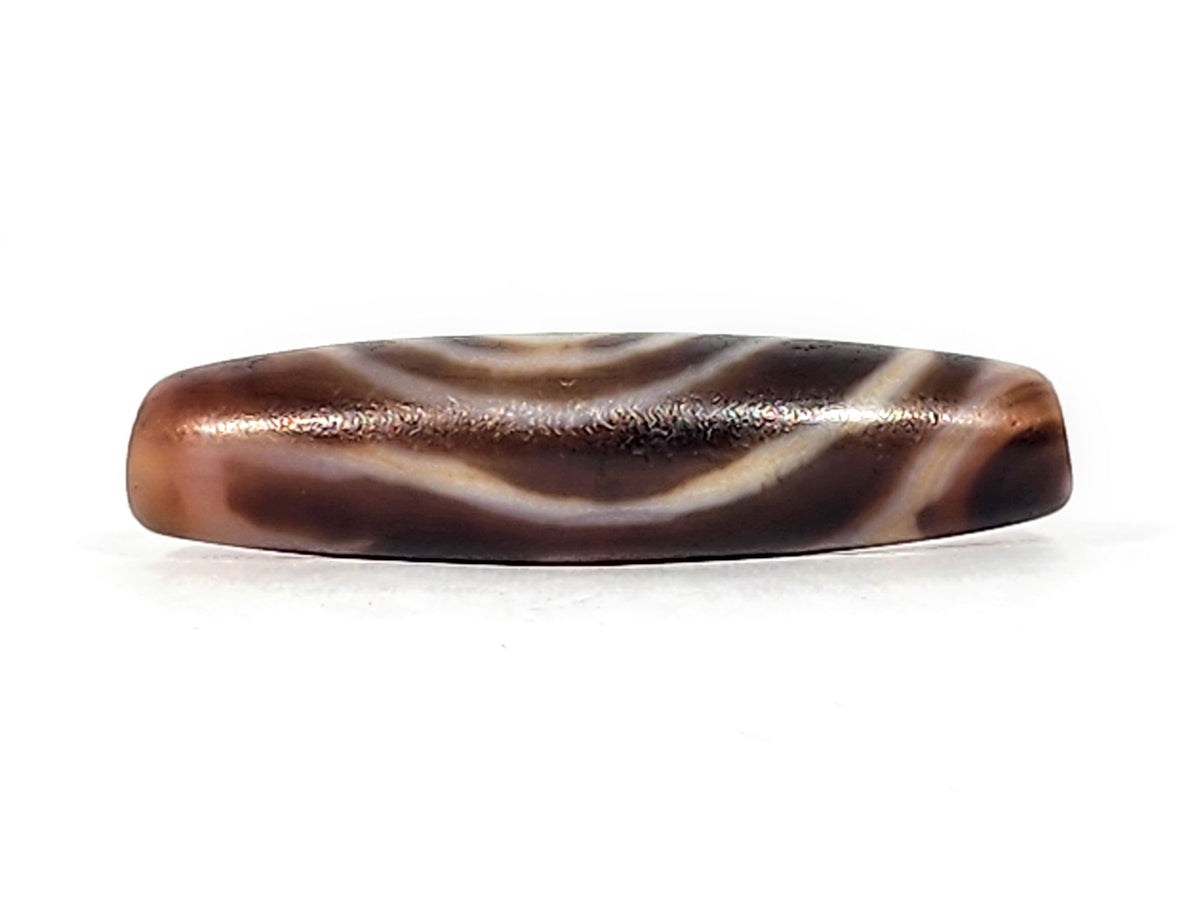 Antique eye-in-eye heaven gate dzi — top profile, wave lines on dark flat face, copper ridge patina, At-0426-EIE