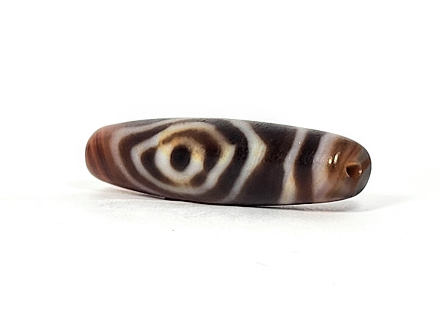 Antique eye-in-eye heaven gate dzi — angled view, Eye-in-Eye with amber toning, drill hole at narrow right tip, At-0426-EIE