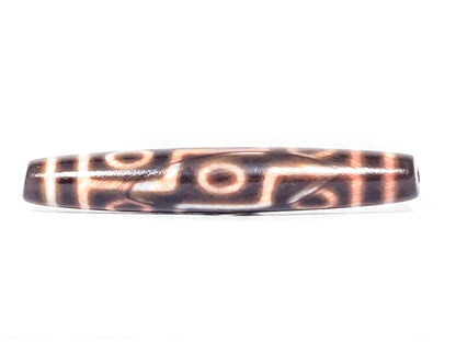 At-062926-9EBS face A, 77.0×12.8mm deep dark brown antique nine eye dzi, warm cream-peach motif lines, unretouched