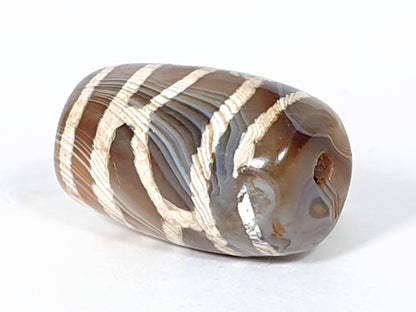 Antique longevity dzi — angled end, lattice on body, orange-red agate inclusion near drill hole tip, At-0426-Lon2