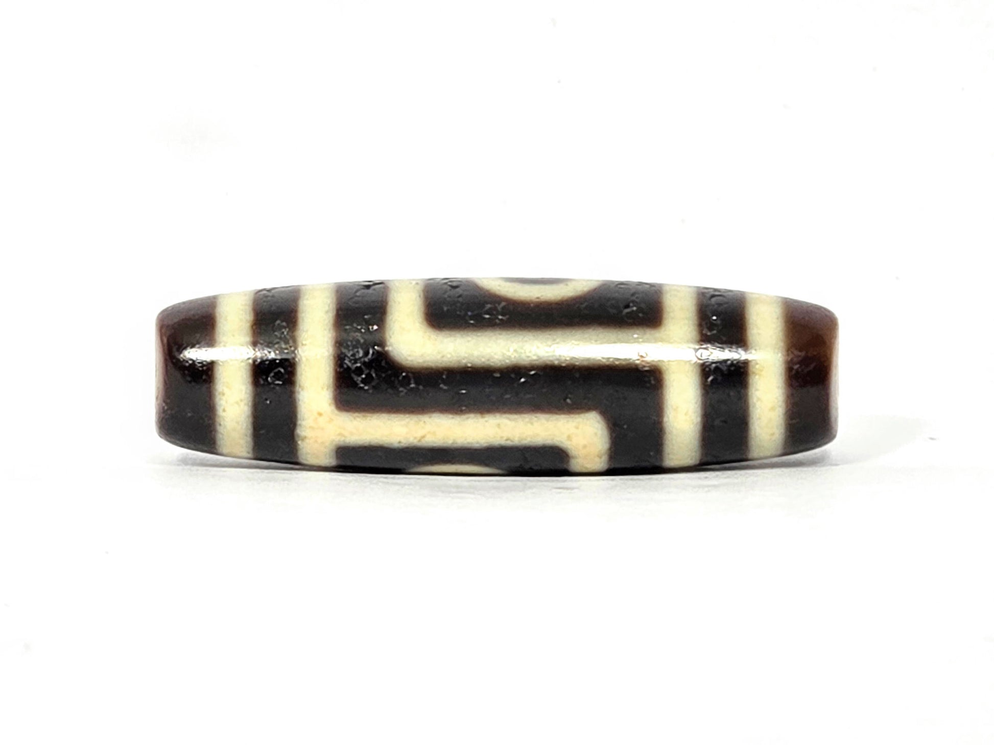 N-090525-2E stepped-line face, angular geometric cream pattern, pitch-black agate centre, unretouched