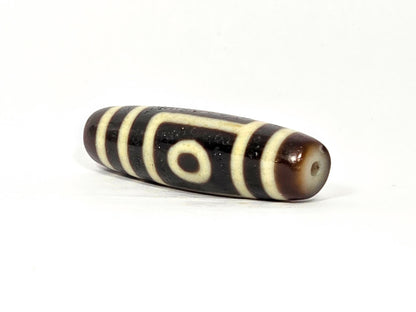 N-090525-2E angled drill-end view, dark brown end cap, eye visible near drilling, unretouched