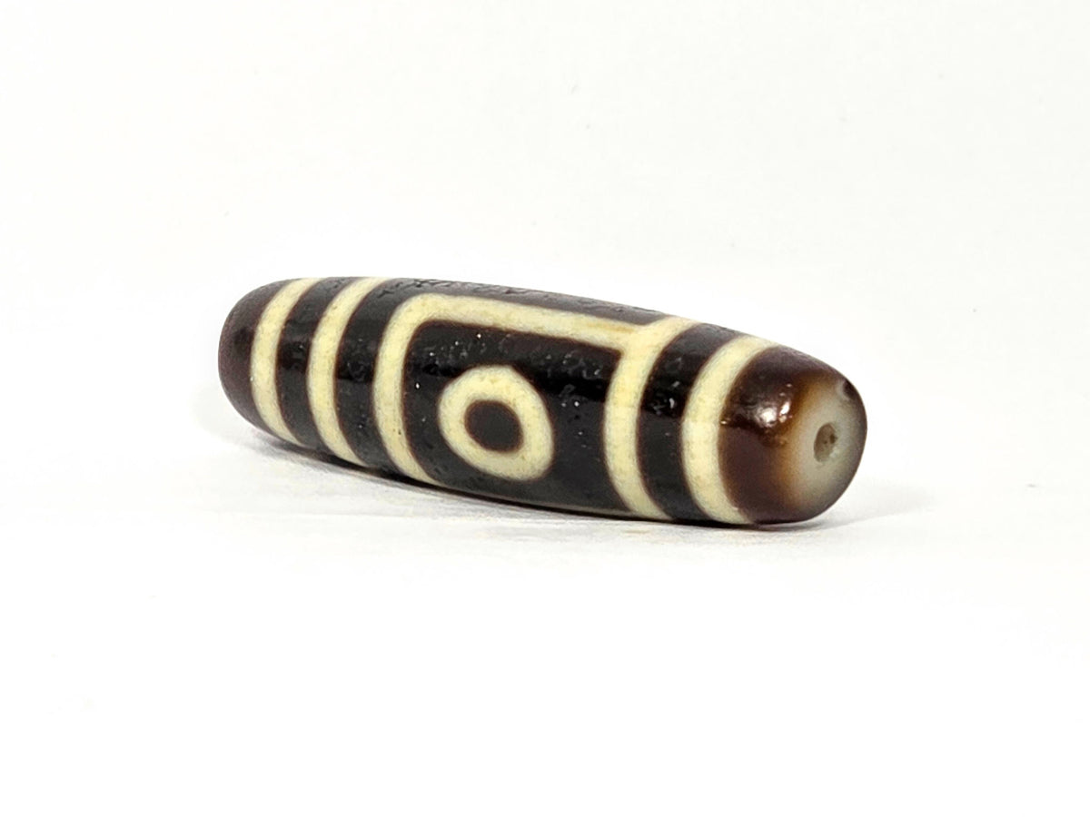 Two eye dzi bead, dark brown and black agate with cream stripes, 39.9×11.6mm, polished surface with drill hole