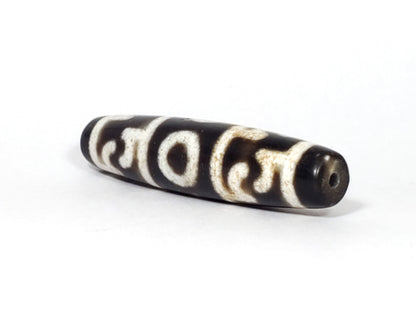 N-062226-GRRP, angled view toward narrow tapered tip, drill hole centred, motif wrapping body, unretouched